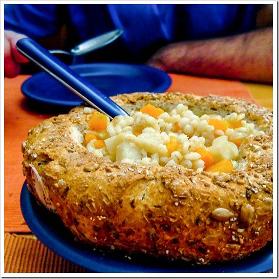 Barley soup with carrots, lentils, turnips and onions, served in a whole grain bread bowl